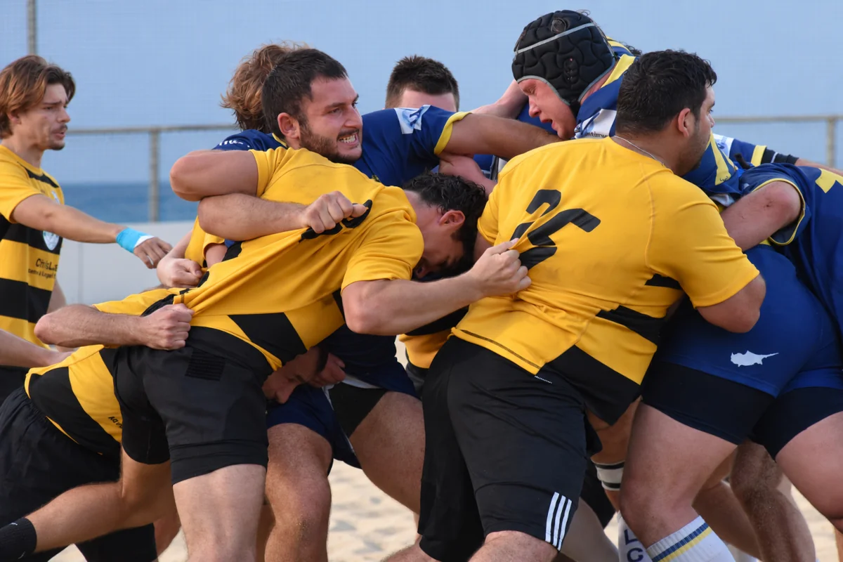 Nicosia Rugby Club players in yellow and black drive forward.